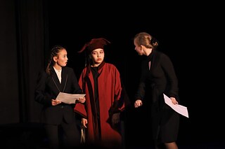 Drei Schülerinnen während einer Theateraufführung