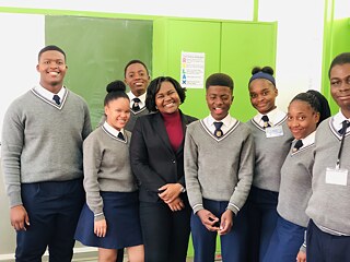 Schülerinnen und Schüler in Uniform, mit Lehrkraft im Klassenzimmer