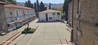 Betonierter Platz umgeben von Gebäuden, mit türkischer Flagge