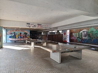 Freizeitbereich mit Tischtennisplatten, an den Mauern Graffitis