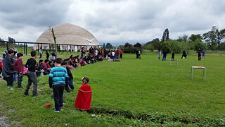 Veranstaltung im Freien, große Schülergruppe auf Freifläche im Grünen