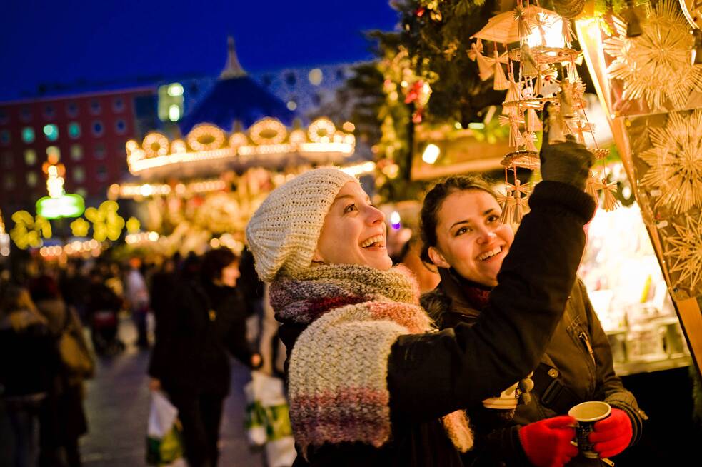 Zwei Frauen bewundern die leuchtende Auslage auf dem Leipziger Weihnachtsmarkt