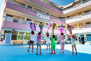 Sechs Kinder, die Schultüten in die Höhe recken