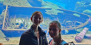 Zwei junge Frauen vor einem großen Aquarium