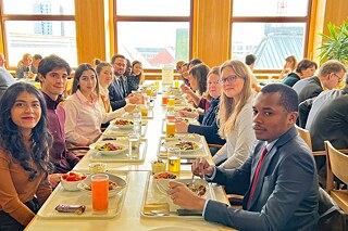 Jugendliche an einem langen, gedeckten Tisch