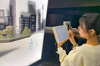 Junge Frau mit einem Tablet in der Hand im Futurarium in Berlin.