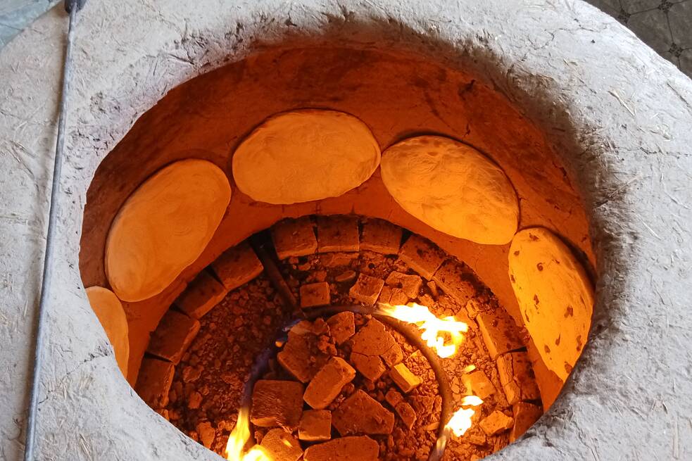 Blick in einem mit Fladenbestückten Tandoor-Ofen