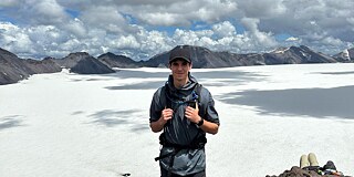 Ein junger Mann auf dem verschneiten Gipfel des Vulkans Sollipulli im Süden Chiles