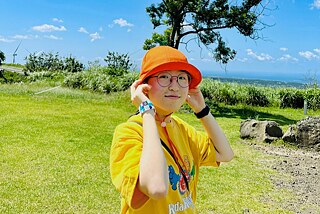 Eine junge Frau mit einem orangefarbenen Hut in einem Park