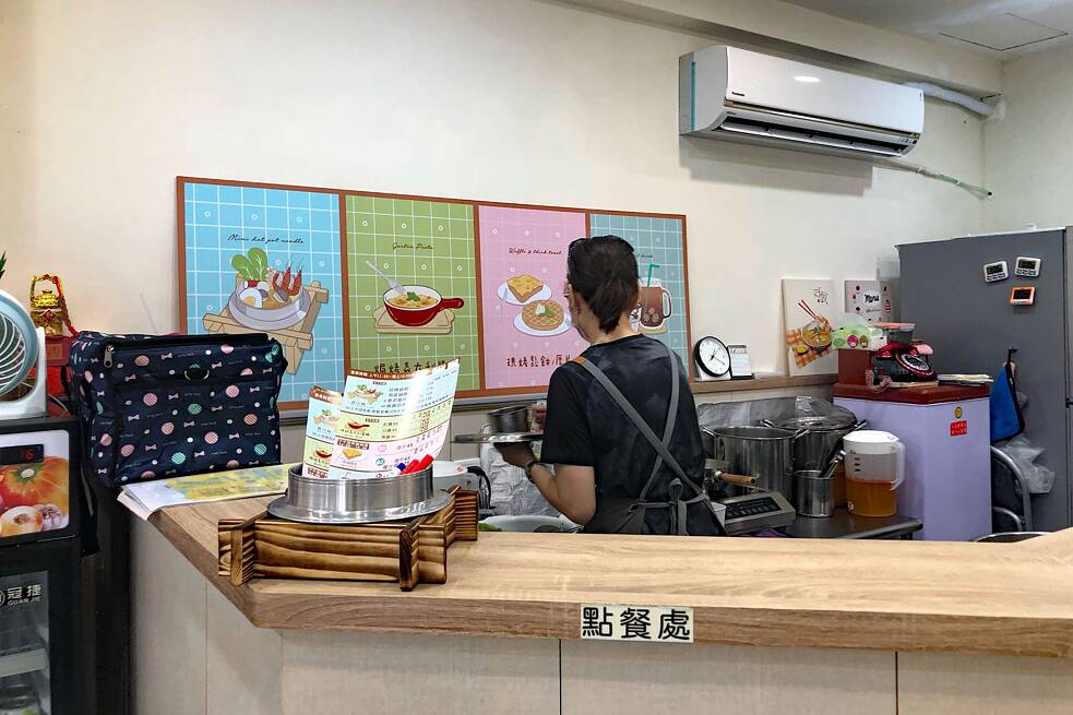 Isolde mag die Köchin des Restuarants „Hua–Tasi“ sehr In einer Restaurantküche, im Vordergrund ein Tresen, im Hintergrund eine Köchin von hinten