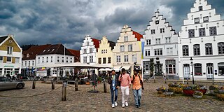 Stadtbild von Tönning, Jugendliche genießen ein Eis aus der Waffel.