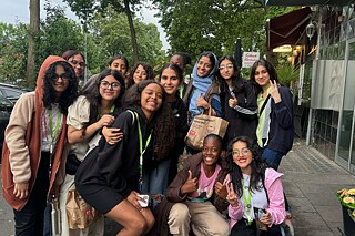 Eine Gruppe junger Frauen posieren für ein Foto vor einem Blumenladen.