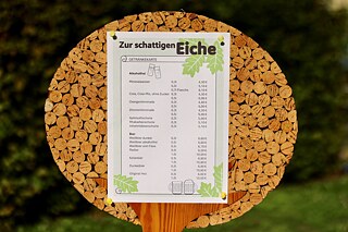 Die Getränkekarte Auf einem mit Flaschenkorken beklebten Brett ist eine Getränkeliste befestigt.