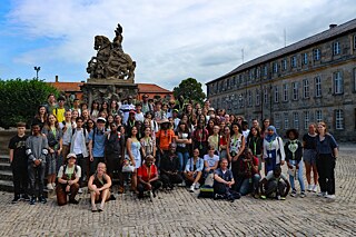 Eine Gruppe Jugendlicher vor dem Markgrafenbrunnen vor dem Neuen Schloss in Bayreuth 