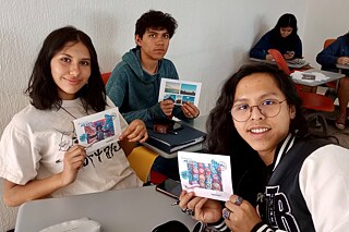 Schülerinnen und Schüler präsentieren ihre Postkarten.
