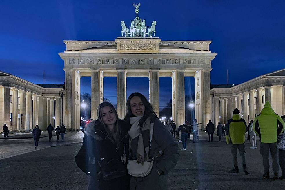 Zwei Frauen vor dem Brandenburger Tor bei Nacht