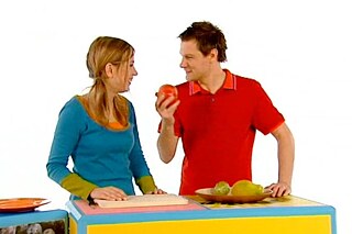 Ein Mann und eine Frau stehen vor einer Obstschale mit verschiedenen exotischen Früchten.