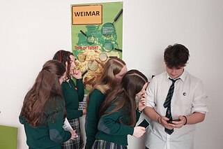 Jugendliche in Schuluniform blicken auf ihre Smartphones