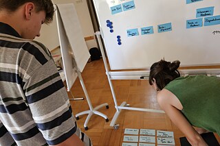 Mindmapping beim Workshop „Authentisch Agieren als Jugendguide“ Junge Leute blicken auf beschriftete Karten.