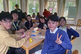 Eine Gruppe Jugendlicher knüpfen Freundschaftsbänder.