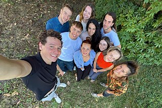 Junge Menschen machen ein Selfie auf einer Wiese.