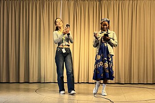 Zwei junge Frauen stehen auf einer Bühne.