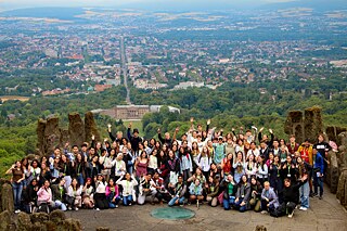 Gruppe auf dem Herkulesdenkmal, in Hintergrund der Blick auf die Stadt Kassel