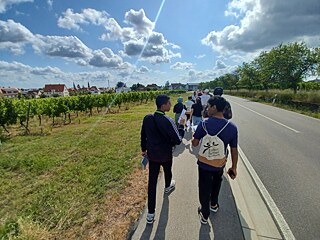 Jugendliche zu Fuß unterwegs auf einem gepflasterten Gehweg.