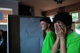 Zwei junge Menschen lachen, einer hält sich die Augen zu.