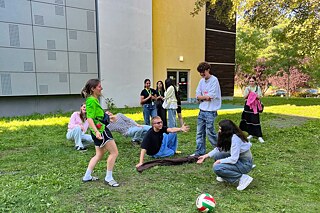 Jugendliche spielen auf einer Wiese.