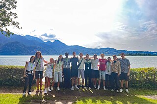 Kleine Gruppe junger Menschen am Seeufer