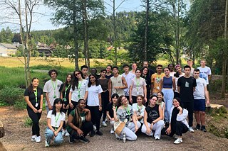 Jugendliche in Sportkleidung posieren für ein Gruppenbild.