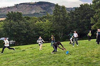 Jugendliche spielen auf einer Wiese.