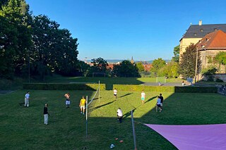 Jugendliche spielen Volleyball in einem Park.