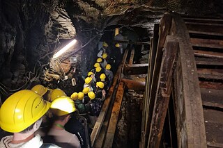 Jugendliche steigen hinab in das Bergwerk.