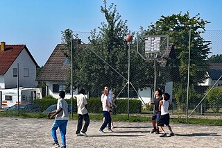 Jugendliche spielen Basketball.