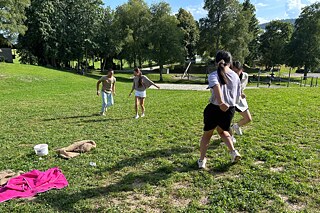 Jugendliche spielen auf einer Wiese.