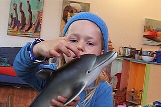 Ein Kind mit einem Delfin in einem Kinderzimmer