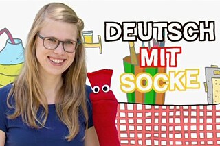 Deutsch mit Socke © WDR  Intro-Bild zu "Deutsch mit Socke", zu sehen ist eine Frau, die in die Kamera lächelt. Neben ihr ist eine rote Socke zu sehen.