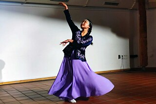 Junge Frau tanzt in Tracht.