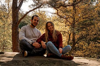 Ein Mann und eine Frau sitzen auf einem Stein in der Natur