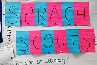 Ein Plakat auf dem in bunten Buchstaben Sprachscouts steht.