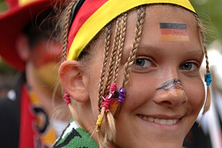 BKD-Kalender 2018 © picture-alliance / Fotograf: Sven Simon Mädchen, geschminkt mit Deutschlandfahne auf der Wange