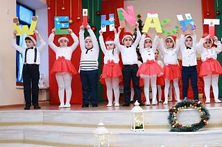 Schülerinnen und Schüler singen und tanzen bei der deutschen Weihnachtsfeier