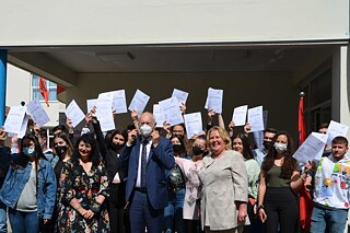 Gruppenfoto vor dem Schuleingang von Schülern und Lehrkräften mit medizinischen Mund-Nase-Masken