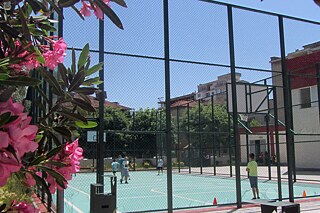 Blick auf den Sportplatz, auf dem zwei Personen Tennis spielen