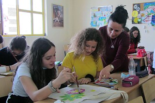 Schüler und Schülerinnen lernen mit Lehrkraft im Klassenzimmer