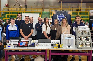 JU Srednja elektrotehnička škola Mostar, Wettbewerb Schülerinnen, Schüler und Lehrkräfte vor einem Stand mit mehreren Projektbeiträgen