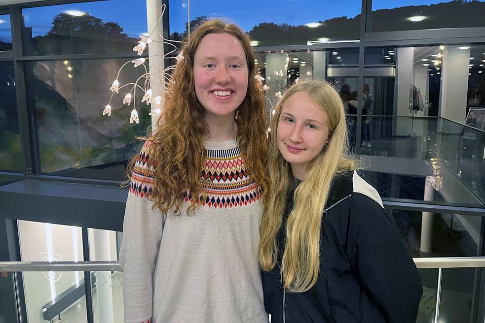Zwei Schülerinnen lächeln in die Kamera.