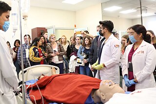 Klasse der UAEH ist um eine Wiederbelebungspuppe versammelt